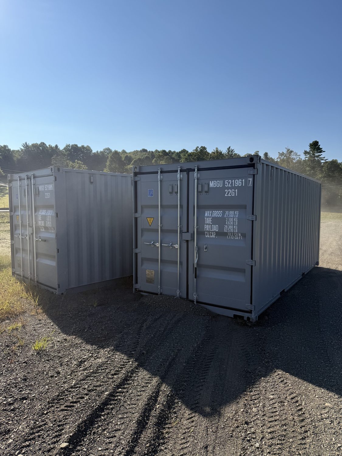 Slate-grey 40-foot shipping container set and leveled on a property